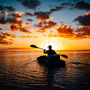 Hommes en katak de mer lors d'un coucher de soleil aux maldives
